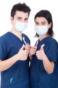 friendly team of dentists, doctors holding toothbrush and showing thumb up sign isolated on white background