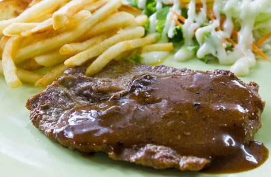 Steak with fresh vegetables salad and french fries