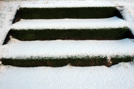 three snow covered steps on tee at a golf course