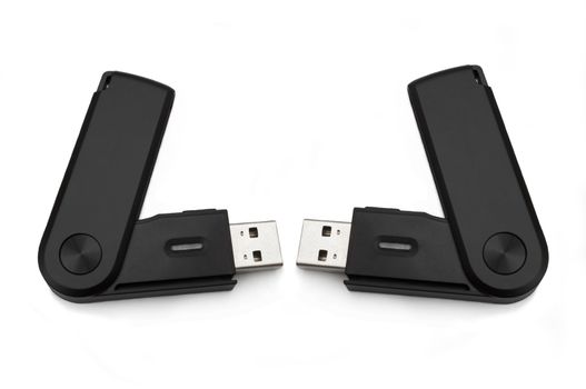 Close up of two black usb sd card adaptors arranged over white
