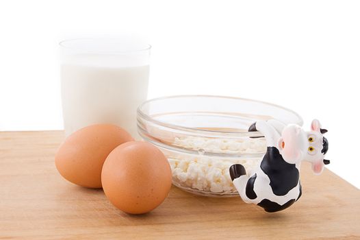 Dairy products and eggs on wooden plate