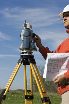 Land Surveyor in the field with theodolite on the tripod.