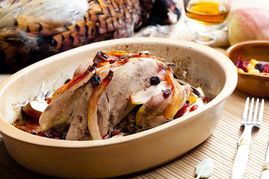 baked pheasant with bacon, pear, raisins on brandy