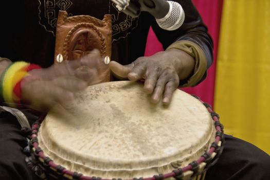 An african man playing a traditional drum by hand