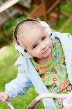 Shot of little girl in headphones playing outside