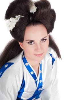 Portrait of the girl of the Asian appearance with a make-up under the geisha on a white background