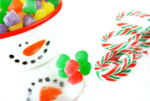 A high key image of Christmas candy.  Candy canes, spice gumdrops and a snowman candy dish.