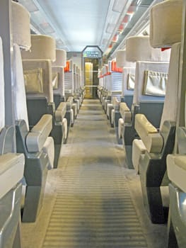 An aisle of a train with a lot of seats.