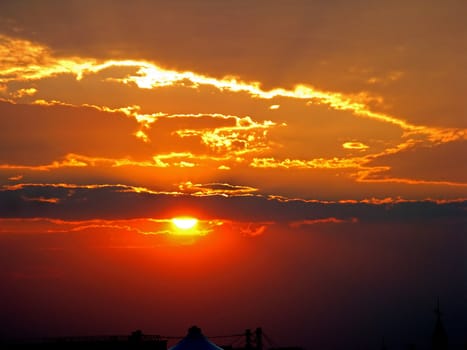 A red and golden burning sunset with clouds.