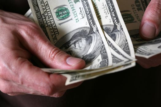 Man's hands hold dollars banknotes money