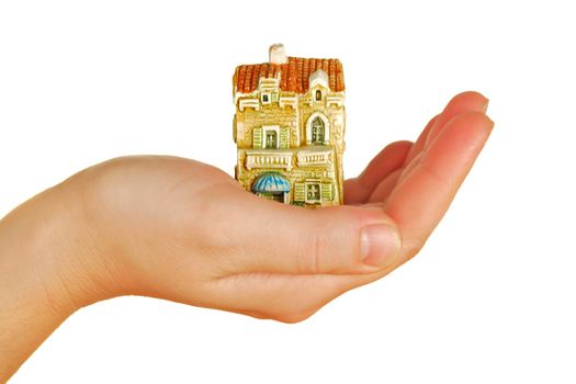 a womanish hand holds a toy cottage on a palm