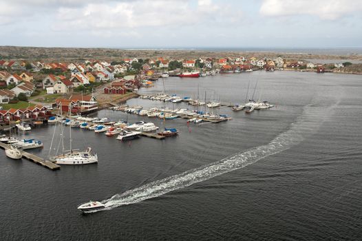 Yacht passing along the marina of a Swedish fishermen village.