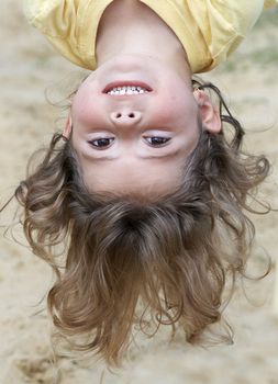a picture of a cute young little girl hanging upsidedown