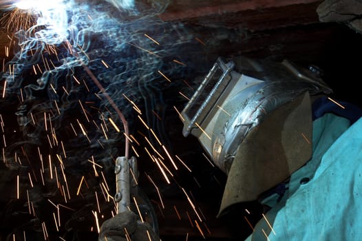 a welder working at shipyard under vessel