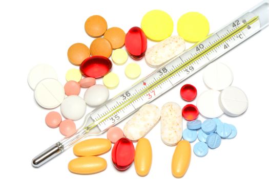 colour pills with thermometer on white background