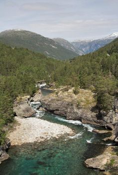 Turns of a mountain river; snow mountain tops in the background