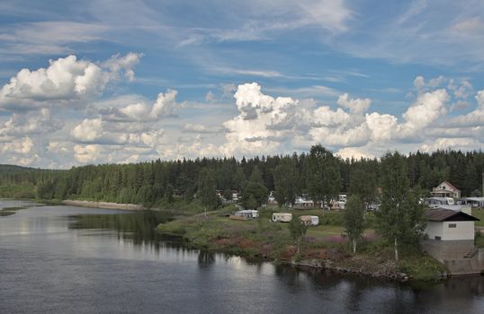 Camping by the river; impressive clouds on a blue sky.