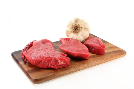 three raw beef rump steaks on a white background
