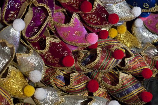A beautiful cdollection of shiny, ornate, colorful turkish slippers in the bazaar.