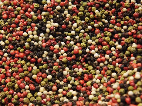 A mixture of red, green, white and black pepper corns.