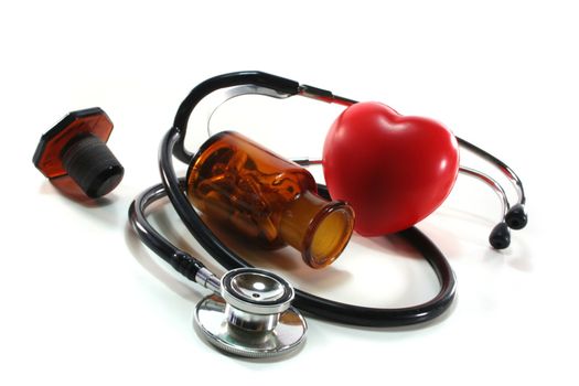 Stethoscope with heart and pills on a white background