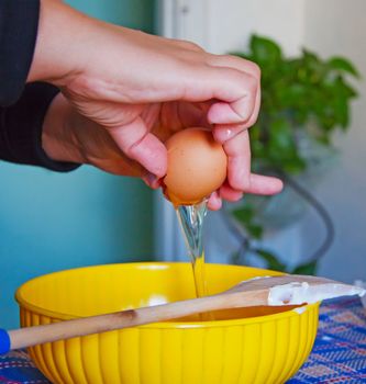 Female hands breaking an egg for a cake