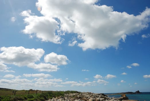 Dune, sea and cloudy sky