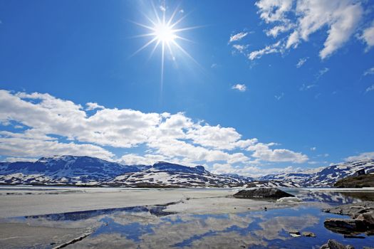 Snowcapped mountains reflecting in the water at Haukeli, Norway