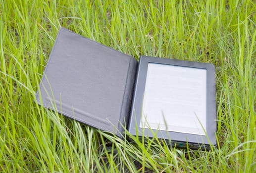 Electronic book reader laying on grass