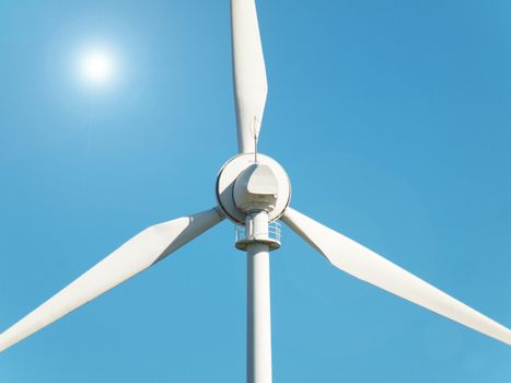 Wind turbine under the sun during  a clear blue sky