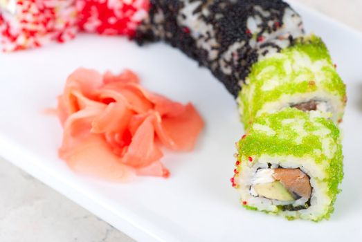 Sushi rolls made of salmon, avocado, flying fish roe - tobiko caviar and philadelphia cheese