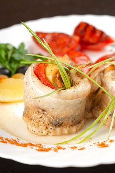 fillet of pikeperch stuffed with trout fish with baked pepper, tomato and leek