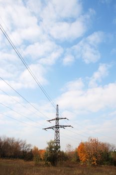 Electric tower poles on the yellow meadow over sky 
