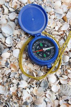 Dark blue compass on sand
