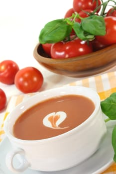 tomato cream soup with dollop of whipped cream and fresh basil