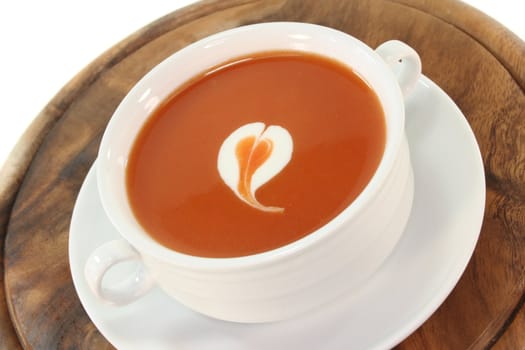 tomato cream soup with dollop of whipped cream in a cup of soup