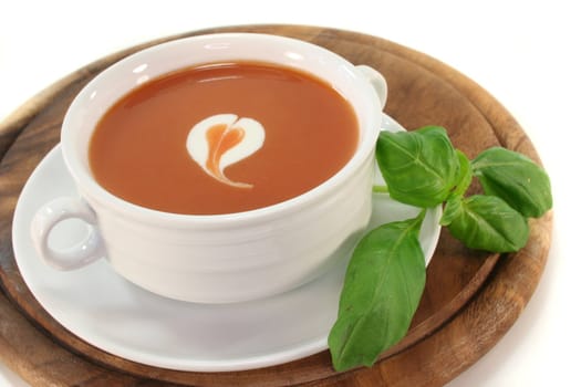 tomato cream soup with dollop of whipped cream and fresh basil