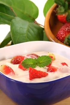 Strawberry yogurt with fresh strawberries on a wooden board