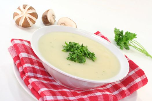 Cream of mushroom soup with fresh mushrooms, bread and parsley