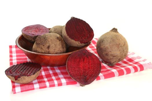 fresh beet root in a wooden bowl on a white background