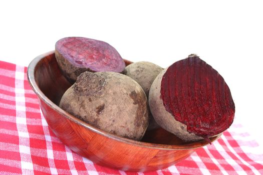 fresh beet root in a wooden bowl on a white background