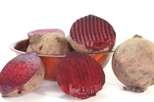 fresh beet root in a wooden bowl on a white background