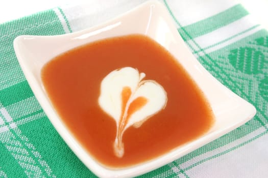 tomato cream soup with dollop of whipped cream in a cup of soup