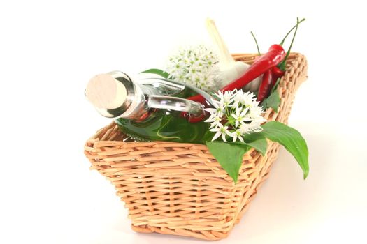 Wild garlic oil with chilli, mixed peppers, garlic and leaves and flowers in the basket