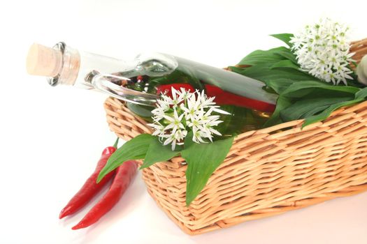 Wild garlic oil with chilli, mixed peppers, garlic and leaves and flowers in the basket