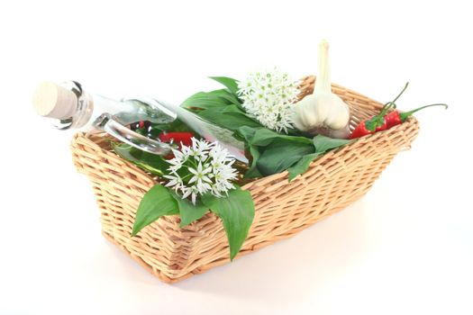 Wild garlic oil with chilli, mixed peppers, garlic and leaves and flowers in the basket