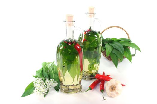 two bottles of Wild garlic oil with leaves and flowers on a white background