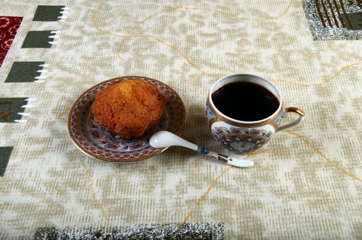 cake with a cup of coffee on the tablecloth