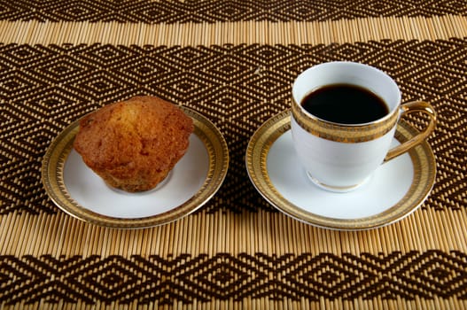 Decorated cup of coffee and cake on a napkin from the plant material