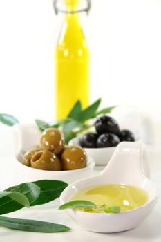 Olive oil with olives and olive branch served in bite spoons
